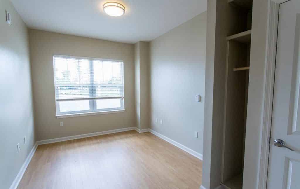 Empty apartment room with closet and double window