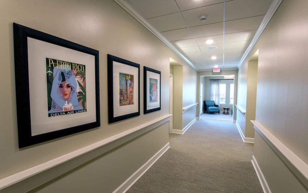 Hallways with art on the walls and seating at the end