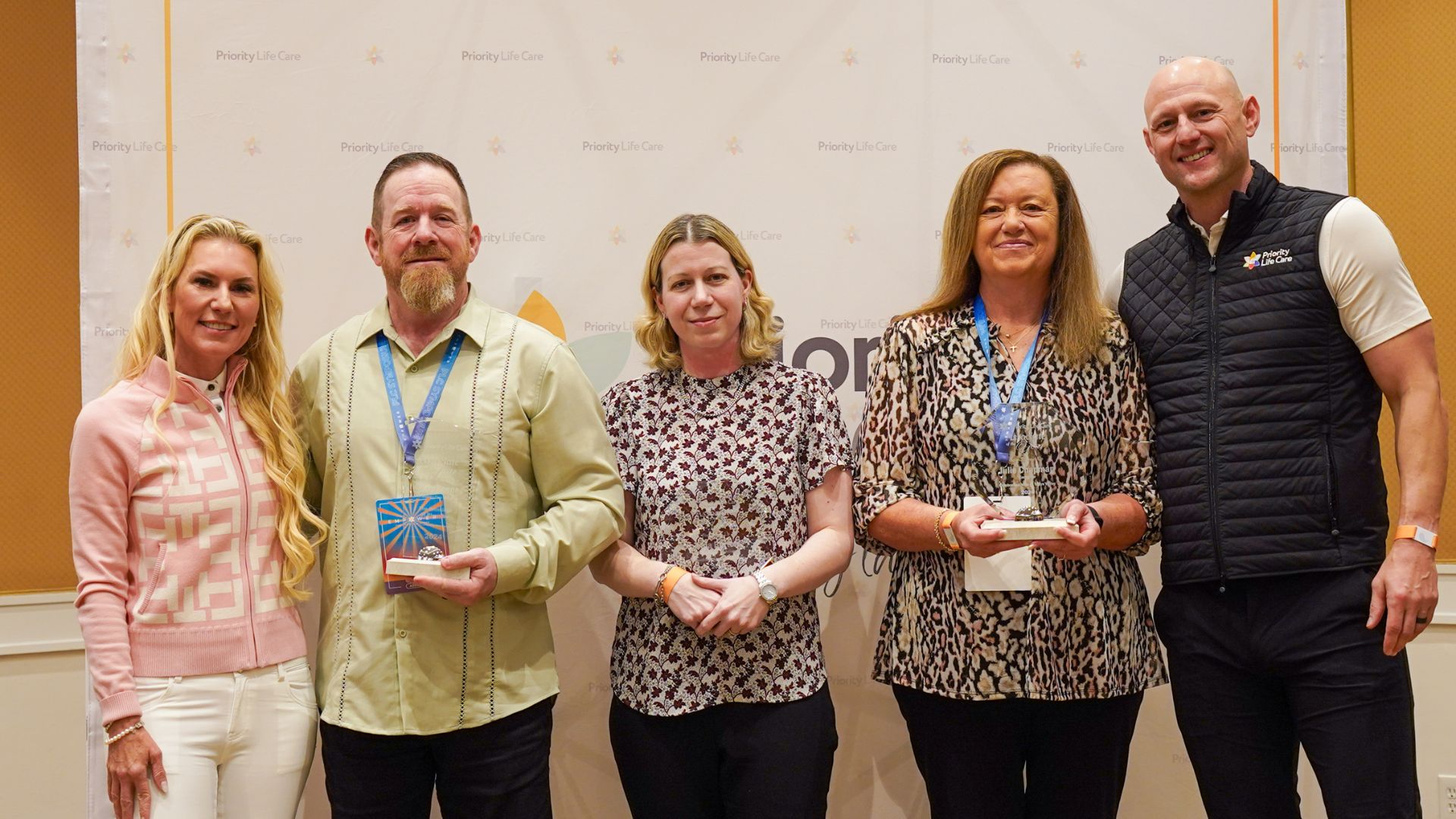 Associate of the Year Winners posing together for a photo with Sevy and Bobby Petras and their awards