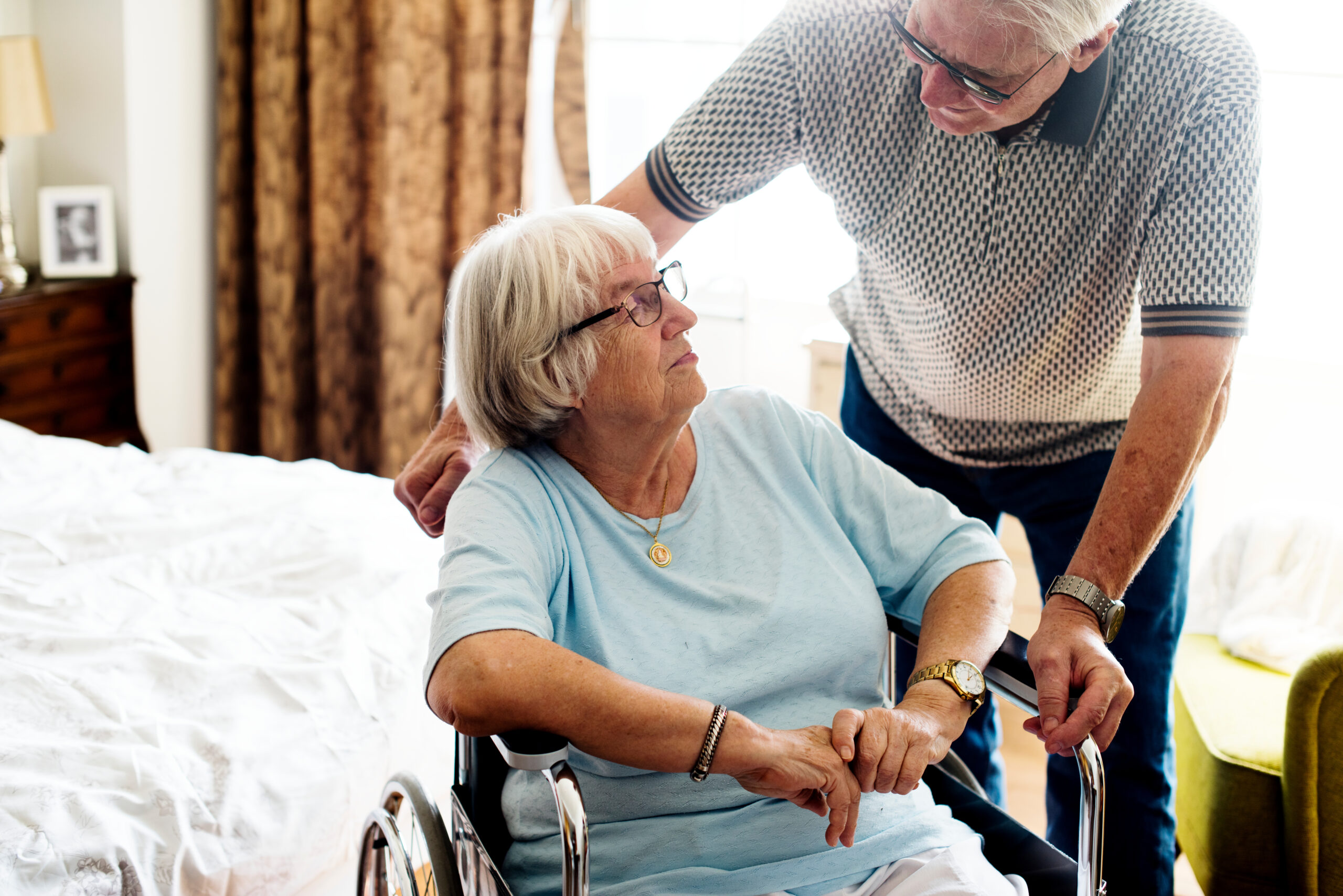 Senior woman in a wheelchair talking to a senior man